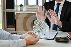 Businessman`s Hand Refusing To Take Bribe cash banknote from business partner, anti-corruption and venalityÂ concept